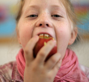 Mädchen beißt in Apfel; Bild: dpa
