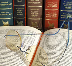 Aufgeschlagenes Buch mit Lesebrille