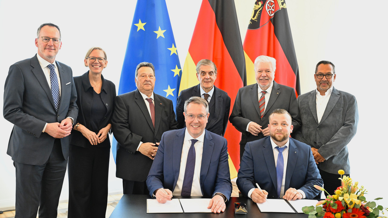 Ministerpräsident Alexander Schweitzer und der Vorsitzende des Landesverbandes Deutscher Sinti und Roma, Christian Kling, unterzeichnen den Staatsvertrag.