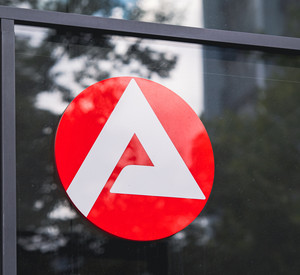 Das Logo der Agentur für Arbeit ist an einer Fensterscheibe zu sehen.