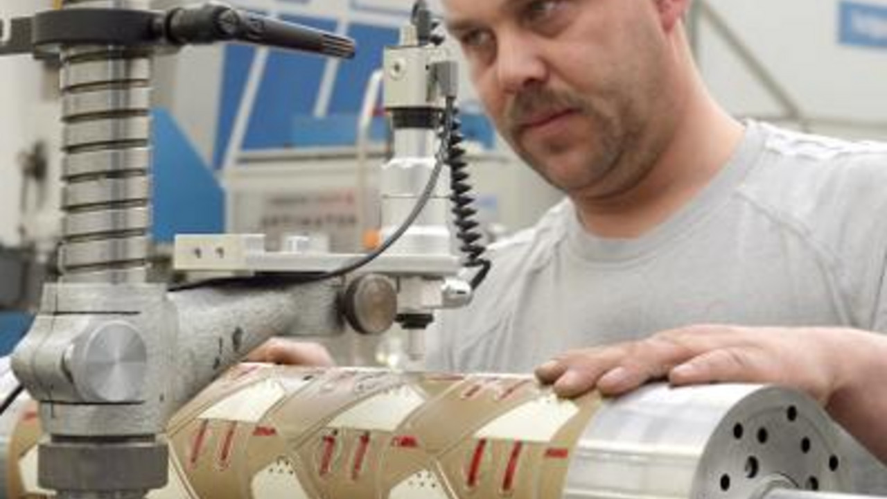 Arbeiter an Maschine; Bild: dpa