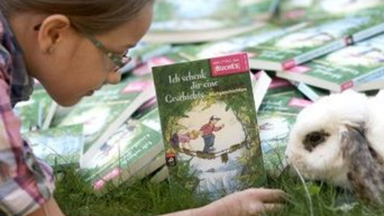 Mädchen mit dem Buchgeschenk; Bild: dpa