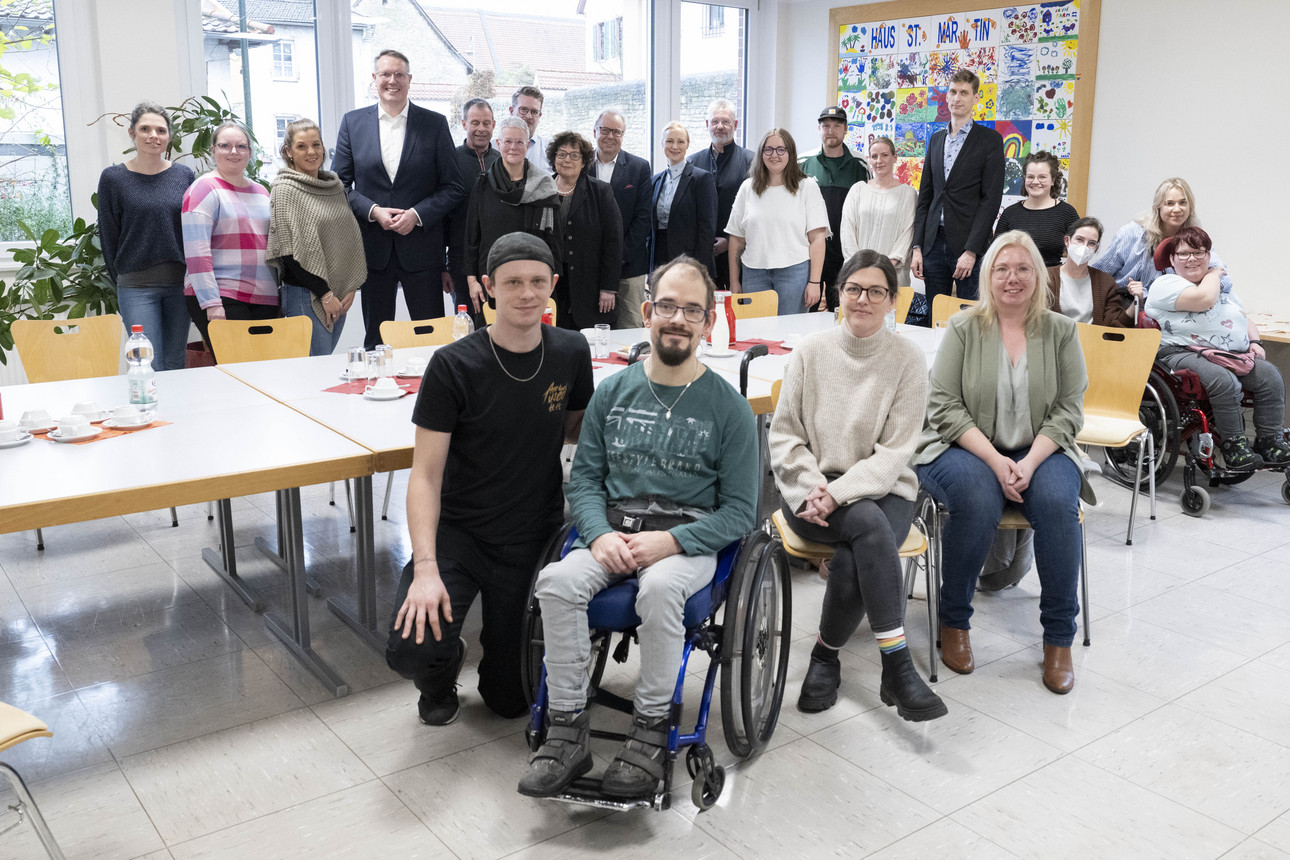 Gruppenbild mit Ministerpräsident Alexander Schweitzer und Sozialministerin Dörte Schall sowie dem Team und Bewohnerinnen und Bewohnern des Hauses St. Martin der Caritas in Ingelheim.