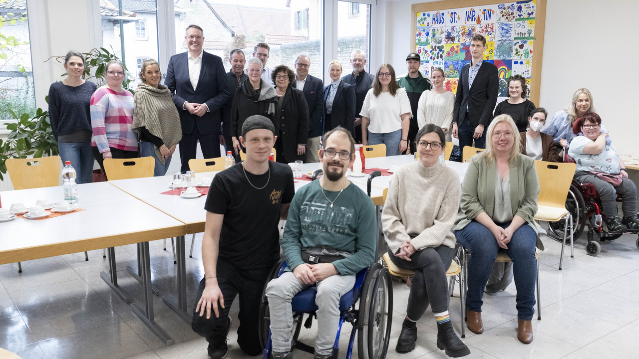 Gruppenbild mit Ministerpräsident Alexander Schweitzer und Sozialministerin Dörte Schall sowie dem Team und Bewohnerinnen und Bewohnern des Hauses St. Martin der Caritas in Ingelheim.