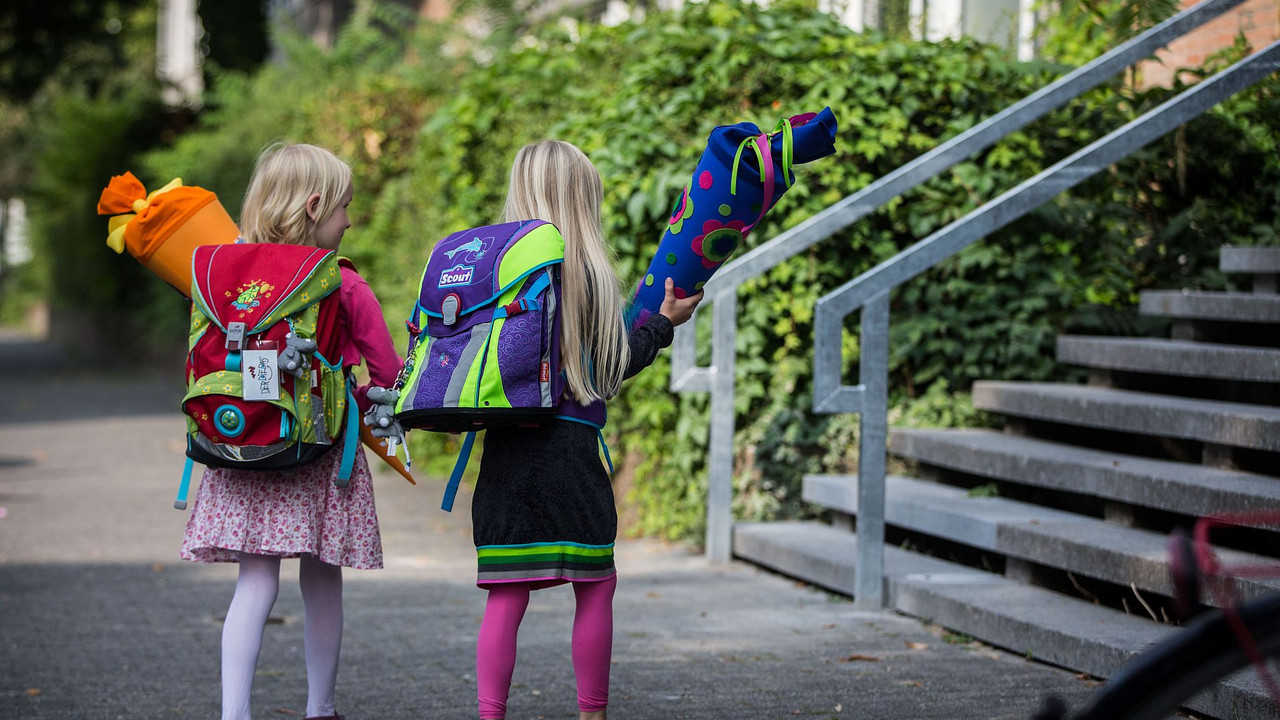 Zwei Erstklässlerinnen mit Schultüte auf dem Weg zur Schule
