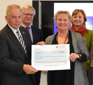 Frauenministerin Irene Alt überreicht dem Vorsitzenden des Partnerschaftsvereins Rheinland-Pfalz-Ruanda, Dr. Richard Auernheimer, einen Spendenscheck in Höhe von 5.000 Euro für ein Frauenprojekt in Ruanda. Bild: MIFKJF
