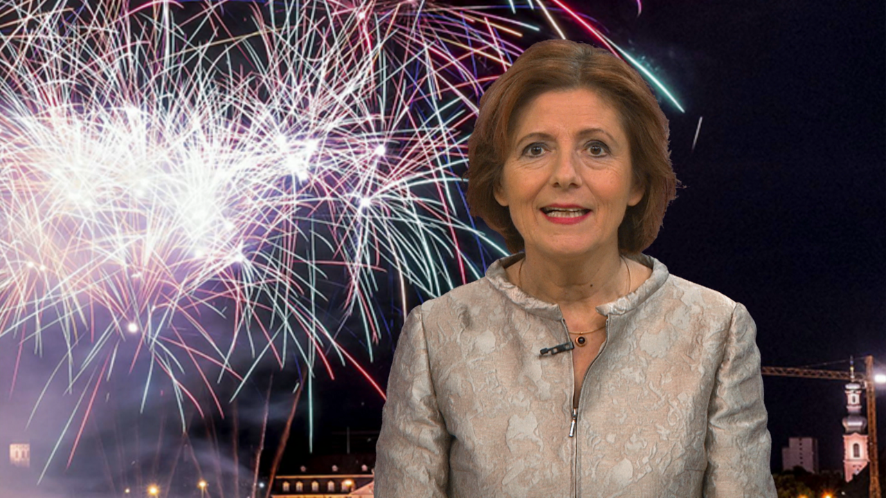 Ministerpräsidentin Malu Dreyer bei ihrer Neujahrsansprache 2023 im SWR vor einem Hintergrund mit Feuerwerk.