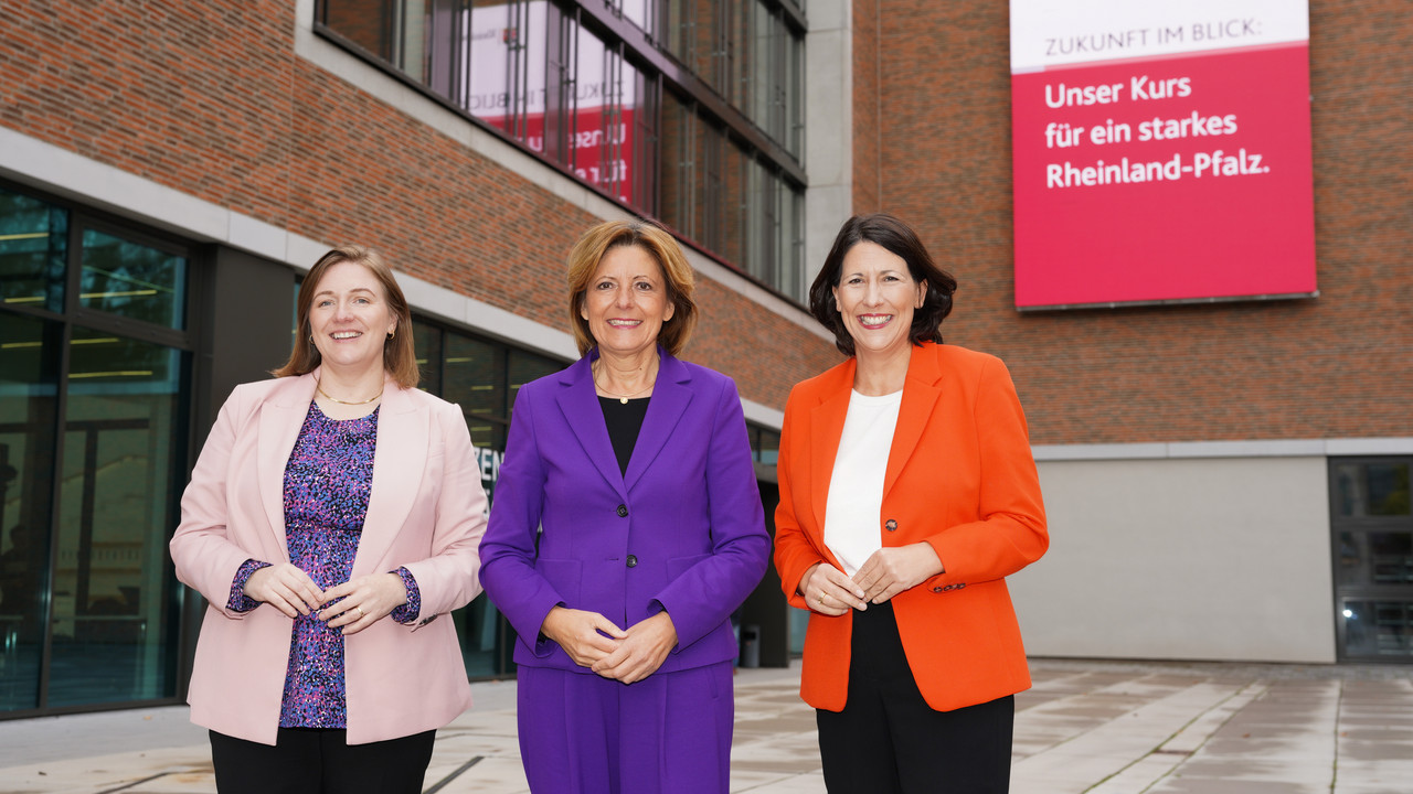 Ministerpräsidentin Malu Dreyer, Ministerin Katharina Binz und Ministerin Daniela Schmitt vorm LEIZA in Mainz. Im Hintergrund ist eine große LED Leinwand mit der Botschaft: "Zukunft im Blick: Unser Kurs für ein starkes Rheinland-Pfalz."