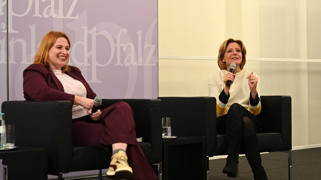 Ministerpräsidentin Malu Dreyer und Politikwissenschaftlerin Natascha Strobl mit Mikrofonen auf Sesseln sitzend.