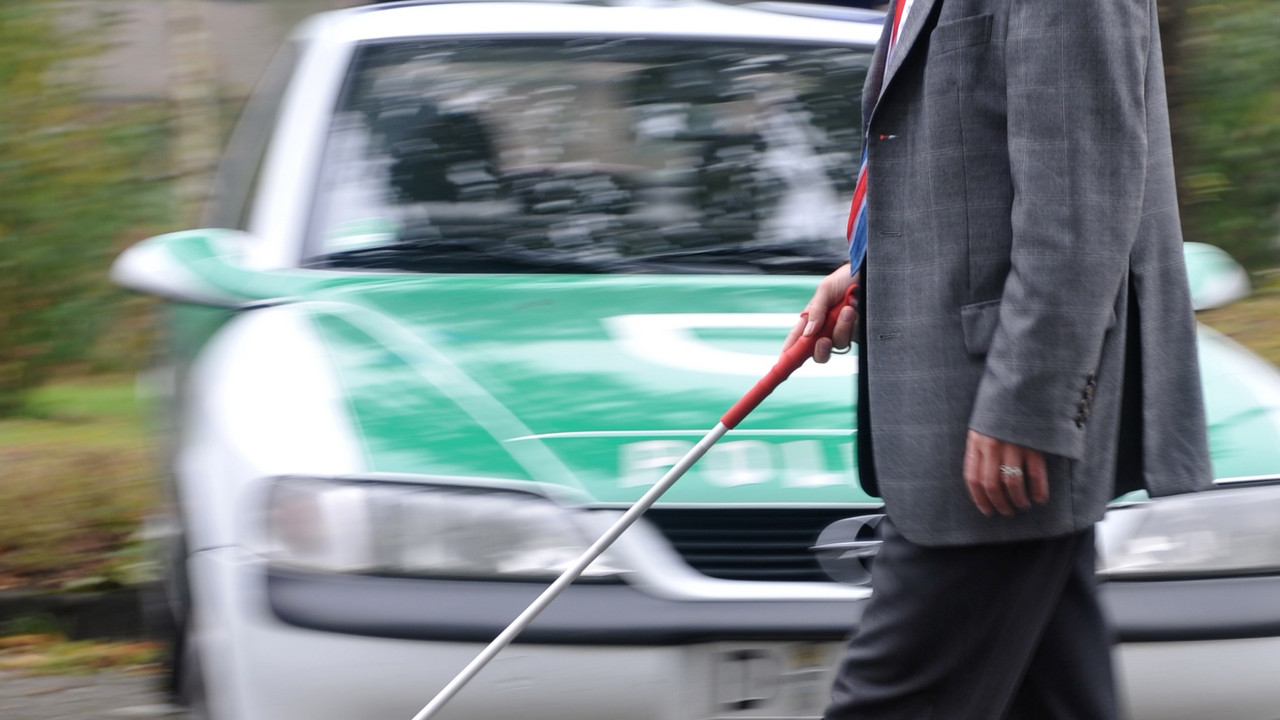Sehbehinderter Mann und Polizeifahrzeug; Bild: dpa