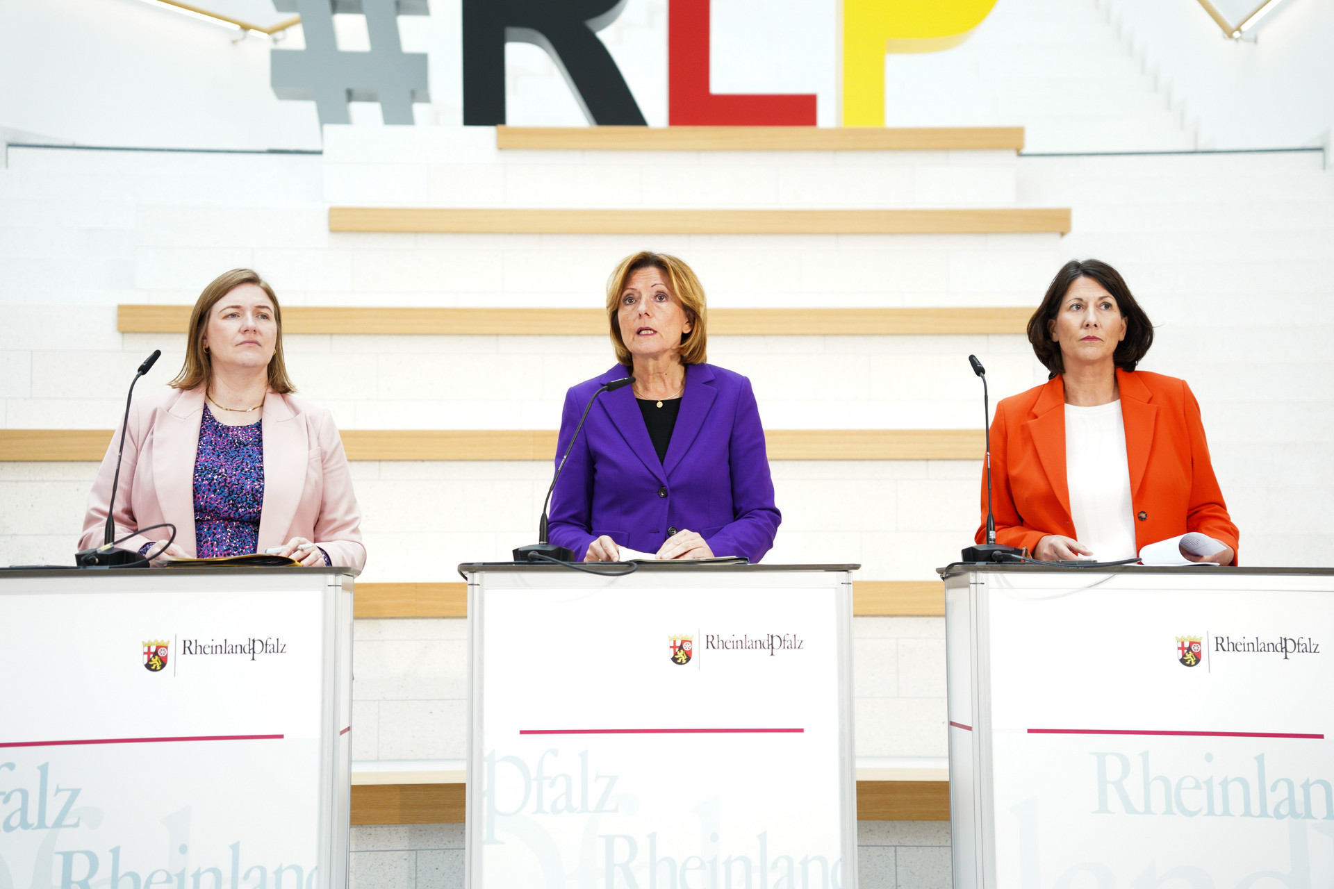 Gruppenbild von Ministerpräsidentin Malu Dreyer, Ministerin Katharina Binz und Ministerin Daniela Schmitt hinter ihren Sprechpulten während der Pressekonferenz.