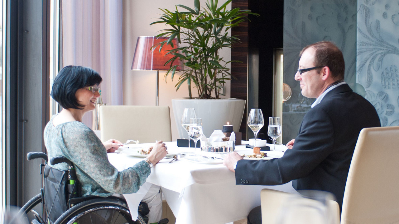 Rollstuhlfahrerin im Restaurant; Bild: Dominik Ketz / © RLP-Tourismus