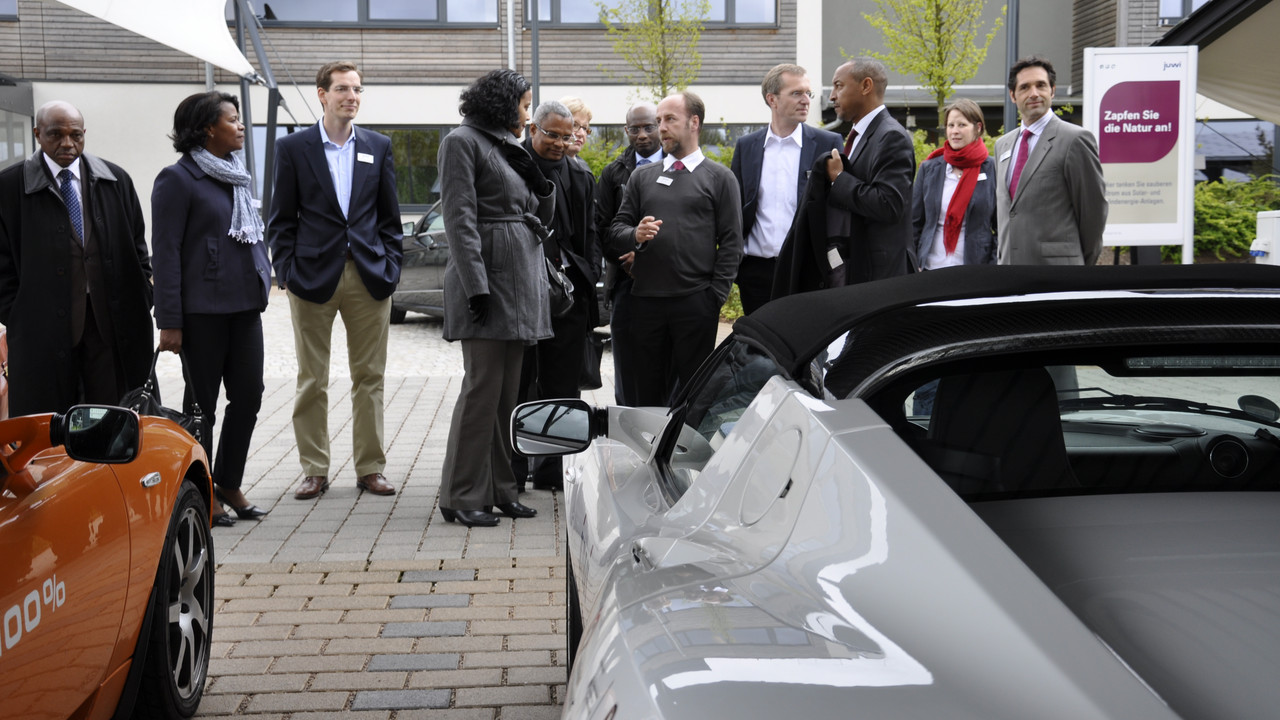 Christian Hinsch, Leiter der juwi-Unternehmenskommunikation und Jochen Magerfleisch (Vorstand juwi) erklären Präsident Neves die juwi Solar-Carports