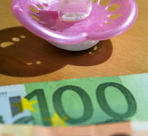 Symbolfoto Betreuungsgeld: Ein Schnuller liegt vor Euroscheinen; Bild: dpa