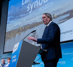 Auf dem Bild ist Alexander Schweitzer bei seiner Rede vor der Landessynode zu sehen.