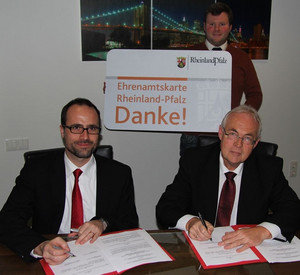 Staatssekretär Clemens Hoch mit Bürgermeister Ottmar Fuchs bei der Unterzeichnung der Kooperationsvereinbarung zur Einführung der Ehrenamtskarte in Flammersfeld