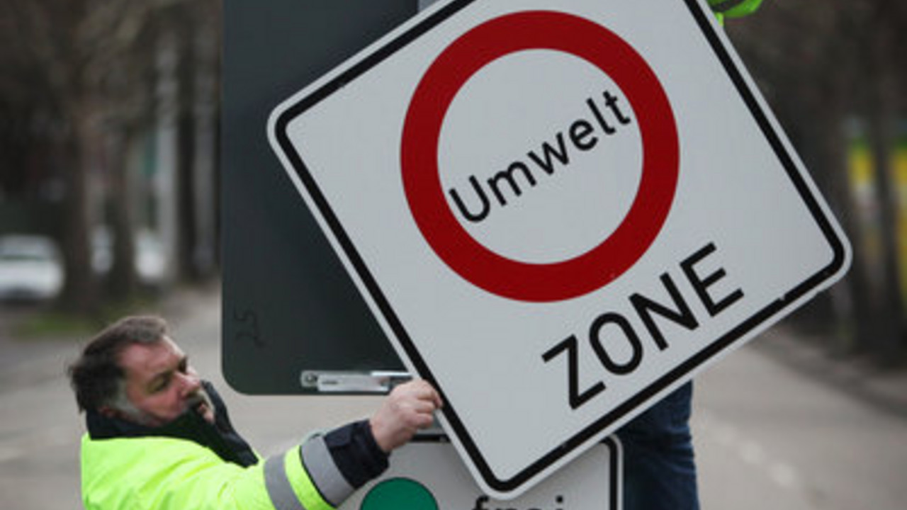 Arbeiter montieren Hinweisschild für die Umweltzone in Mainz; Bild: dpa