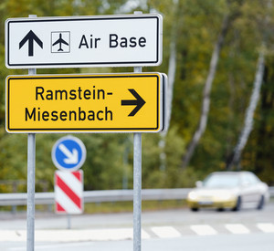 Verkehrsschilder mit der Aufschrift „Air Base“ und „Ramstein-Miesenbach“ stehen an einer Bundesstraße zum Flughafen