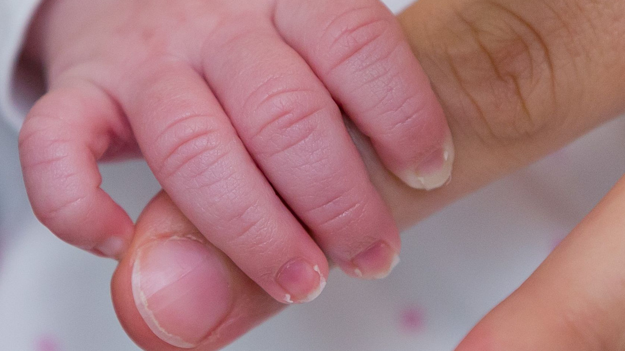 Baby greift nach der Hand eines Erwachsenen; Bild: dpa