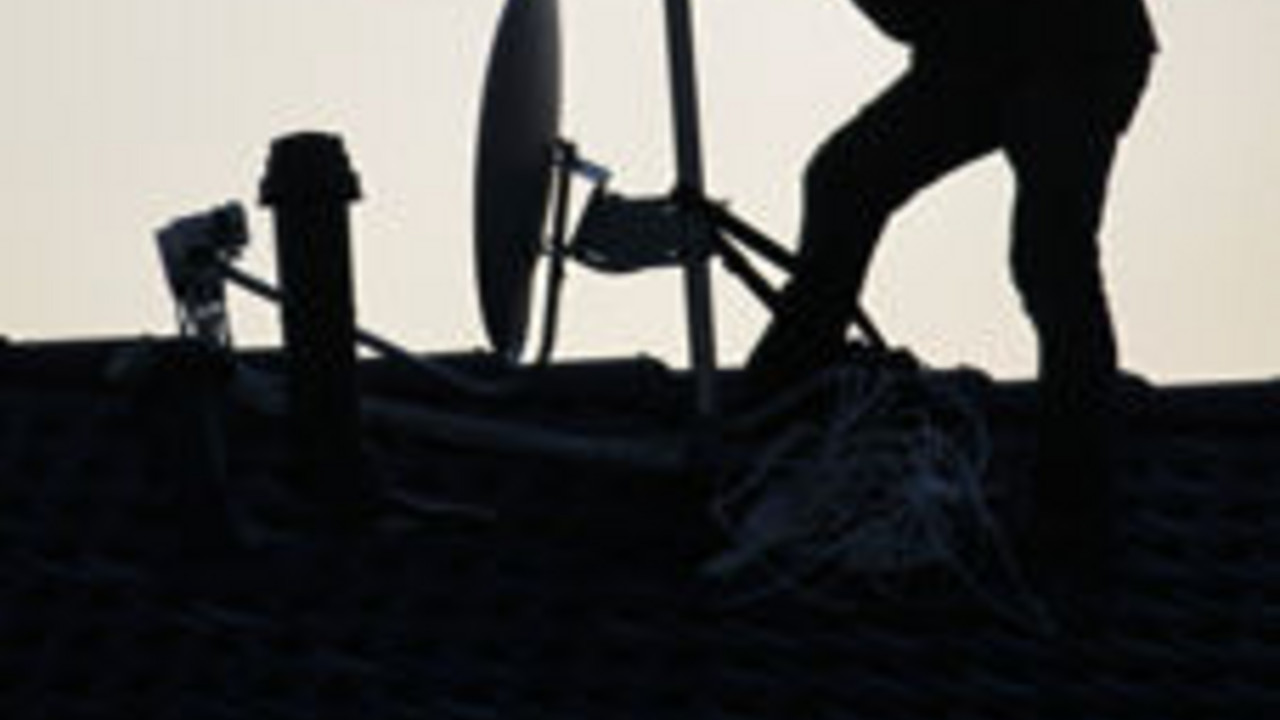 Mann richtet Satellitenantenne aus