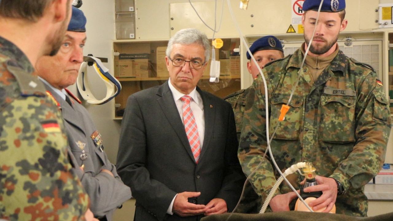 Soldaten demonstrieren an einem Dummy die notärtztliche Versorgung. Innenminister Roger Lewentz und General Tempel schauen zu.