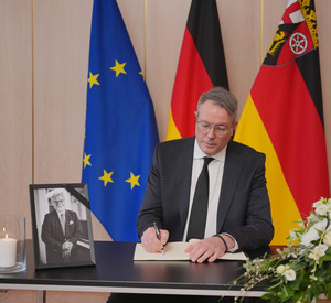 Auf dem Bild ist Ministerpräsident Schweitzer bei der Eintragung ins Kondolenzbuch zu sehen.