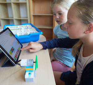 Schülerinnen einer Grundschule mit einem Tablet