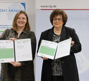Die stellvertretende Ministerpräsidentin Katharina Binz und LIGA-Vorsitzende Regine Schuster halten die unterzeichnete gemeinsame Erklärung ins Bild.