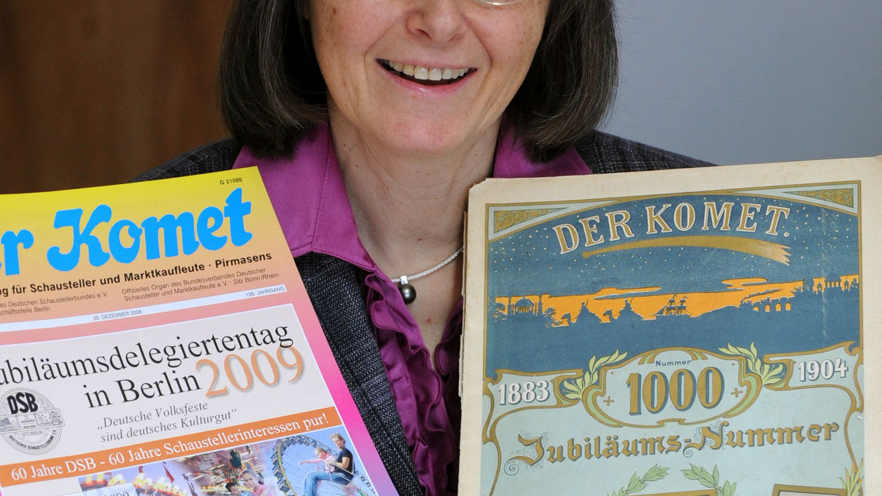 Rita Endres-Grimm, Leiterin der Komet Druck- und Verlagshaus GmbH, zeigt verschiedene Ausgaben der Schaustellerzeitschrift Komet. Das Verlagshaus feiert seit 100-jähriges Bestehen. Bild: dpa
