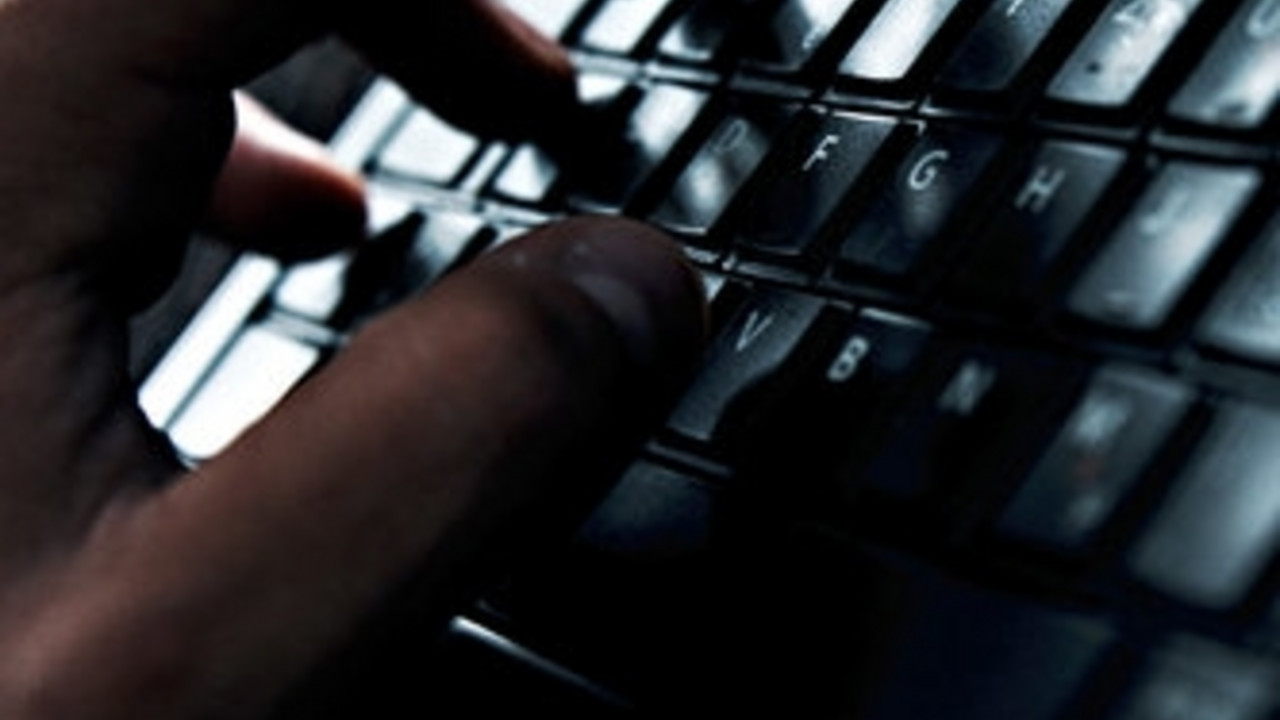 Symbolbild Cybercrime, Hand an Tastatur; Bild: dpa