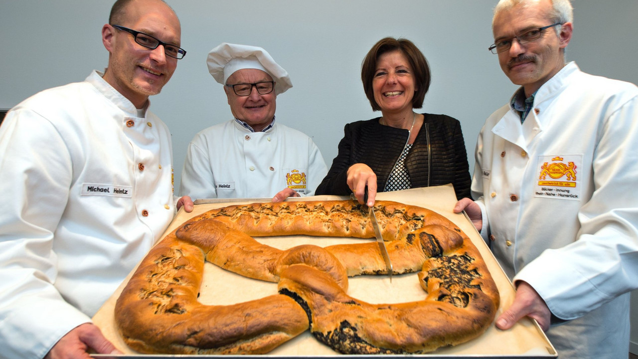 Michael Roller, Vorstandsmitglied der Bäckerinnung Rhein-Nahe-Hunsrück, Bäckermeister und Ehrenmitglied Heiko Heintz und Bäckermeister und Vorstandsmitglied, Michael Heintz (v. r.), überreichten Ministerpräsidentin Malu Dreyer die Neujahrsbrezel; Bi
