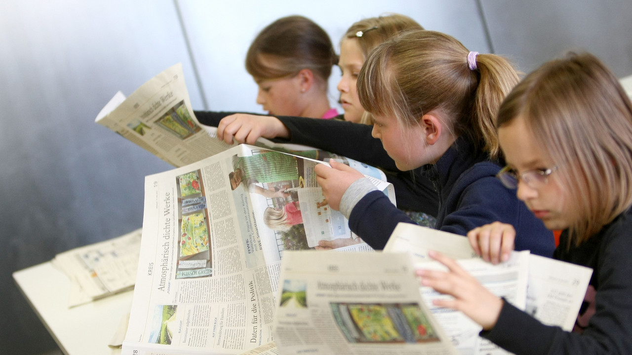 Mädchen lesen Zeitung