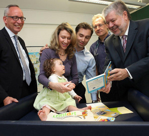 v.l. Hauptgeschäftsführer Jörg Maas, die kleine Carmen-Maria mit Eltern, Dr. med. Pirmin Habermehl, Mininsterpräsident Kurt Beck bei der Überreichung des Lesestart-Sets; Bild: Alexander Sell / © Staatskanzlei