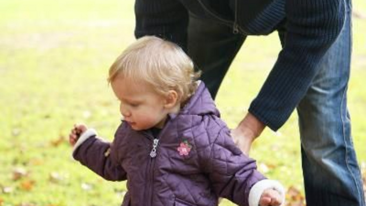 Vater spielt mit Kleinkind im Laub; Bild: dpa