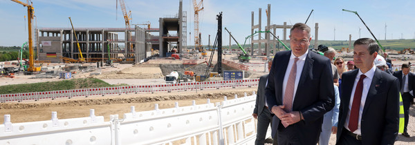 Auf dem Bild sieht man Ministerpräsident Alexander Schweitzer und den CEO Dave Ricks des Pharmaunternehmens Eli Lilly auf der Baustelle in Alzey.