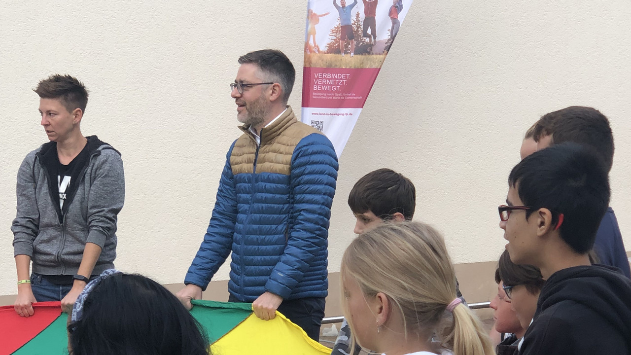 Der Chef der Staatskanzlei, Fabian Kirsch, mit Schülerinnen und Schülern der Landskronschule in Oppenheim.