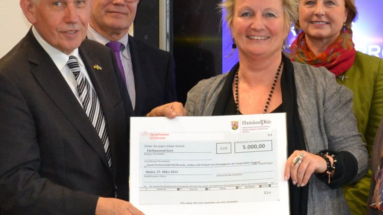 Frauenministerin Irene Alt überreicht dem Vorsitzenden des Partnerschaftsvereins Rheinland-Pfalz-Ruanda, Dr. Richard Auernheimer, einen Spendenscheck in Höhe von 5.000 Euro für ein Frauenprojekt in Ruanda. Bild: MIFKJF