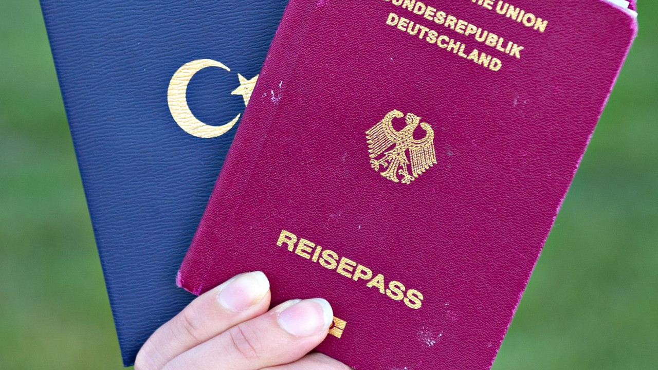 Hand hält einen deutschen und einen türkischen Pass; Bild: dpa