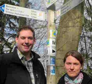 Thomas Kalff, Projektmanager des Wanderweges Moselsteig bei der Mosellandtouristik, und Liane Jordan vom Deutschen Wanderverband vor Moselsteig-Hinweisschildern. Bild: dpa