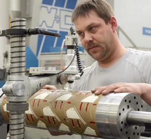 Arbeiter an Maschine; Bild: dpa