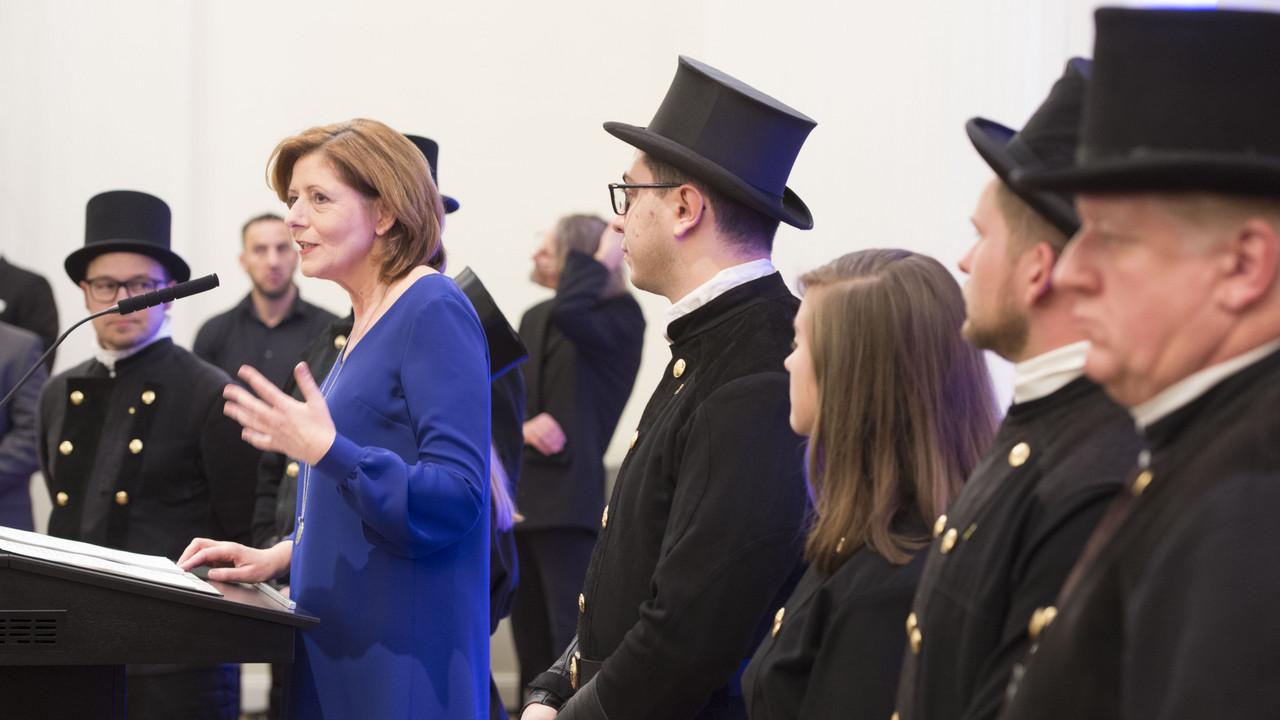 Ministerpräsidentin Malu Dreyer im blauen Kleid bei ihrer Rede zum Neujahrsempfang 2020, im Hintergrund Schornsteinfeger 