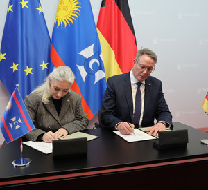 Auf dem Bild ist die Unterzeichnung der Verträge zu sehen.