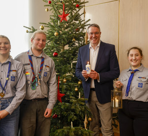 Ministerpräsident Alexander Schweitzer bei der Übergabe des Friedenslichtes.